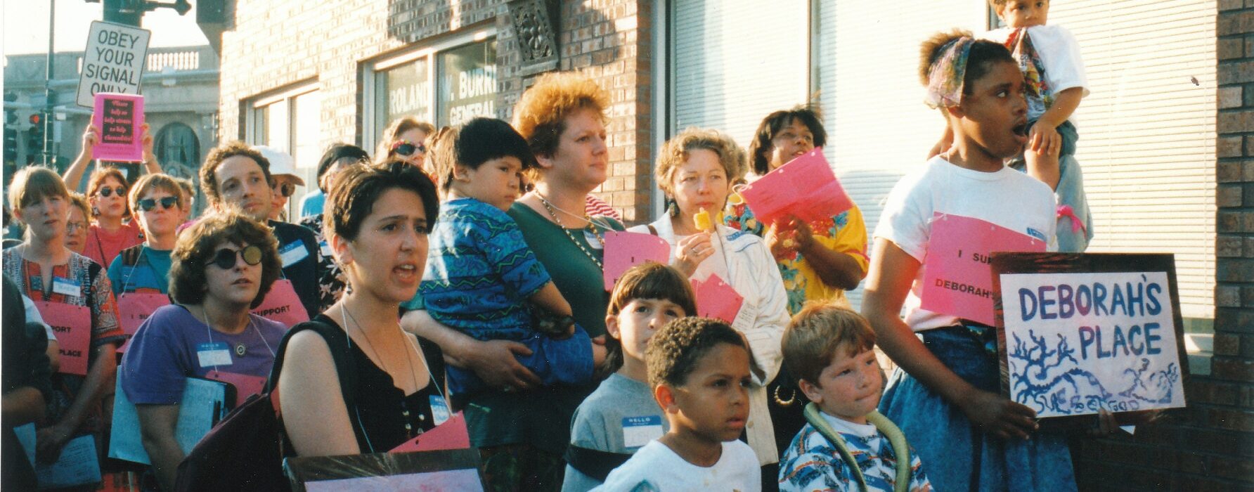 Photograph from 1993 shows a group of community members march with signs that read "Deborah's Place"
